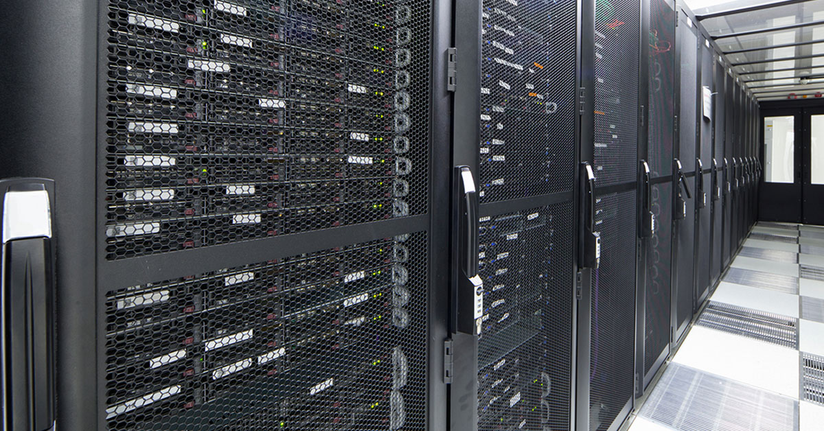 Photograph of black server data center cabinets filled with file servers in hallway.